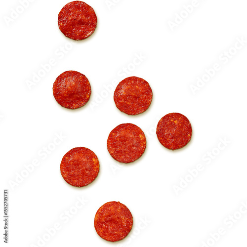 A scattered arrangement of pepperoni slices on a white background.