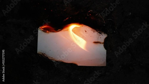 Burning and glowing photo or paper with fire flame and smoke on dark background