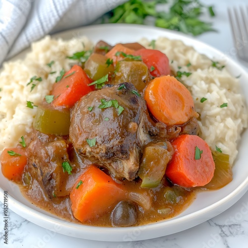 Delicious and Hearty Beef Stew with Vegetables over Rice on a White Plate