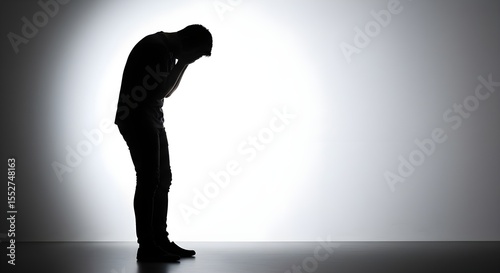 Silhouette captures a poignant moment of despair, highlighting themes of mental health, emotional distress, grief, and the weight of personal problems.