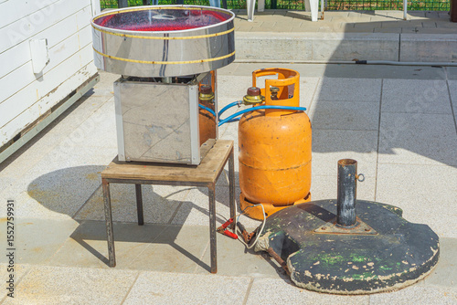 Outdoor cotton candy machine with gas cylinder, concept of fair, celebrations, street food