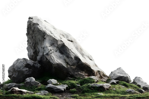 A large, rugged rock surrounded by smaller stones and lush green grass, showcasing the beauty of natural landscapes.