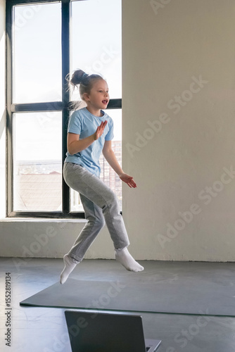 Child enjoys exercise routine in modern indoor space during afternoon.