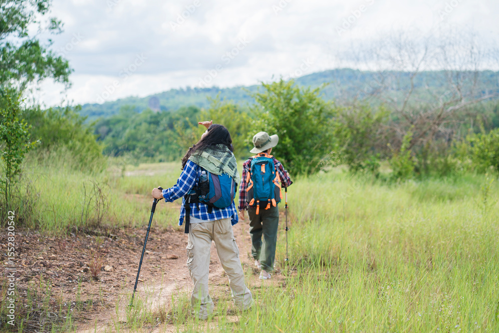 Obraz premium Two young Asian female hikers enjoying an outdoor adventure in nature. Exploring scenic trails, embracing freedom and fresh air during their trekking journey