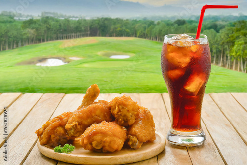 Fried chicken and coke close up with nature background.