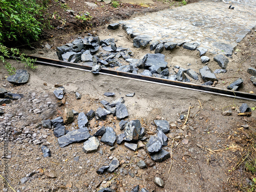 drainage of the threshing floor in the forest beige color transverse metal gutters drain the water into the ditch paved riverbed
