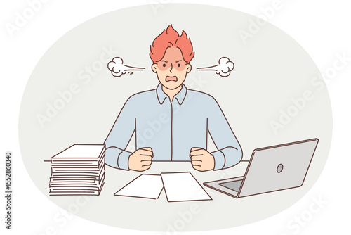 Angry man suffering from overwork and paperwork sitting at office desk with laptop