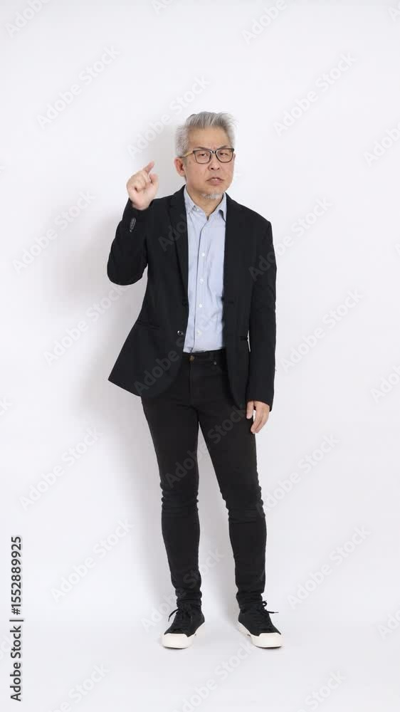 This is a portrait of an East Asian businessman with gray hair and glasses, dressed in a black suit, standing against a white background. This is a portrait of an East Asian businessman with gray hair and glasses, dressed in a black suit, standing against a white background.