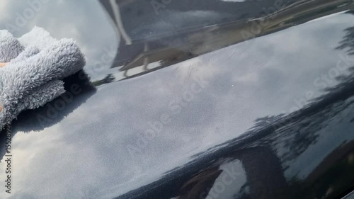 professional service man polishing and detailing on a car body, professional workman waxing a wax on a vehicle. Car wash service.