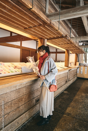 神社で破魔矢を買う日本人女性