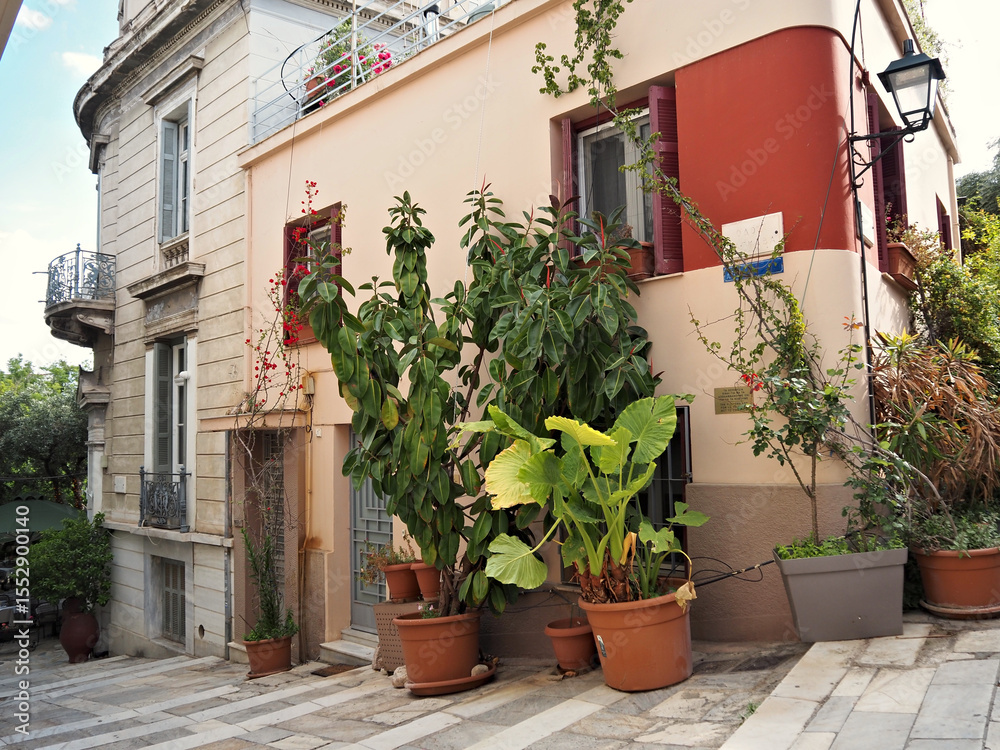 Naklejka premium Mediterranean home exterior with abundant potted greenery and rustic charm.