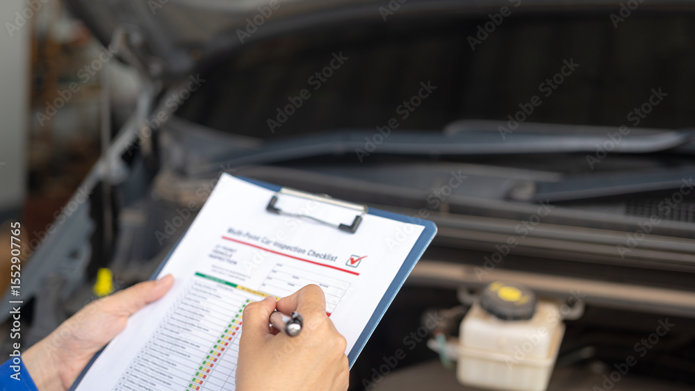 Fototapeta premium Action of a repairman is checking on multi-point checklist form during perform service the car parts. Industrial working scene, close-up and selective focus.
