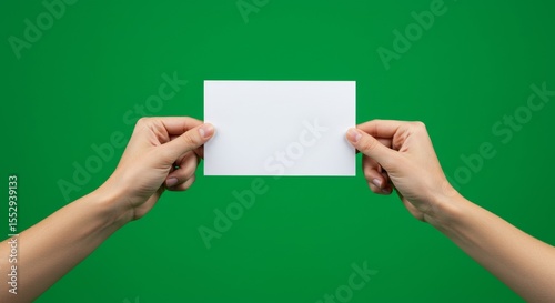 Two Hands Holding Blank White Paper Against Green Background