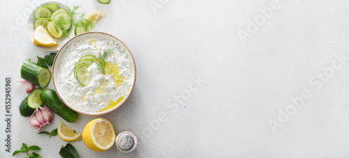 Tzatziki salad with roasted bread in white bowl on white background. Homemade Tzatziki salad with olive oil and copy space. Top view.
