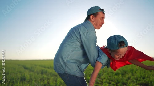 Father and son in field. Father and son playing in a field. A young girl is flying with her imagination and bonding with her friends outdoors. A father and his son in a meadow lifestyle.