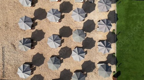 Top-down aerial video of beach umbrellas at white sand beach at sunny day. Nusa Dua. Bali.Indonesia