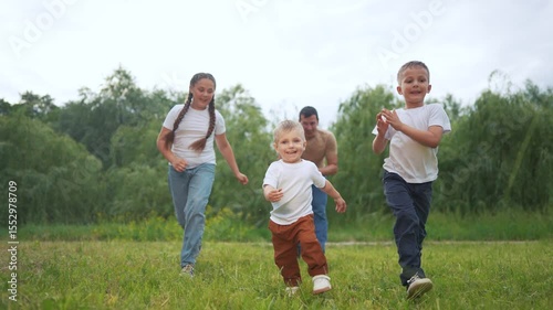 Two boys running in grass. Children running in the grass outdoors. A young girl is playing with a toy in the daytime and is having fun in the afternoon. Two boys sprinting lifestyle through the grass.