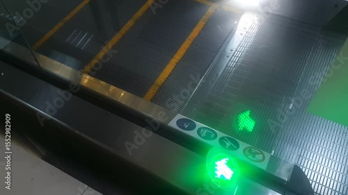 Escalator,an electric elevator in a shopping mall with a lighted arrow sign.