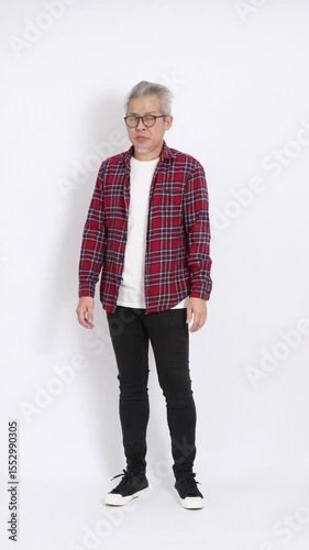 The elderly East Asian man wearing a red plaid shirt is standing against a white background.