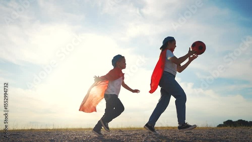 Two children running field. Children running in the field outdoors in the daytime. A boy and girl in a field with a boy and girl in the sunshine. A pair of kids sprinting across the lifestyle meadow.
