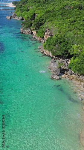 Aerial view of Bali island coastline with rocks and green trees.Nusa Dua.Indonesia.Vertical video