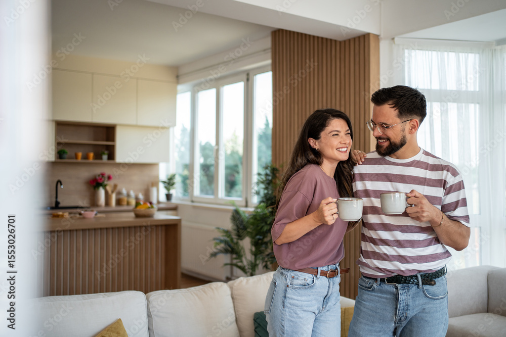 Fototapeta premium Happy couple enjoying morning coffee in modern apartment