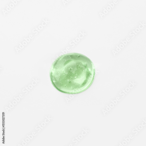 Green cosmetic gel drop on a white background