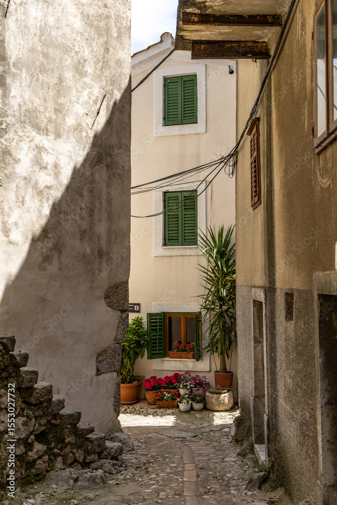 Fototapeta premium The narrowest street in the world, a narrow passage between the high walls of the old town, KRK in Croatia, a tourist attraction