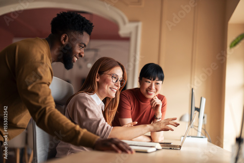 Diverse Team Collaboratively Working on Creative Project in Modern Office Setting