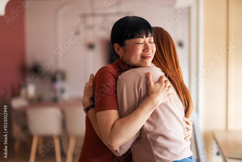 Canvastavla Warm Embrace Between Two Friends in a Cozy Modern Setting