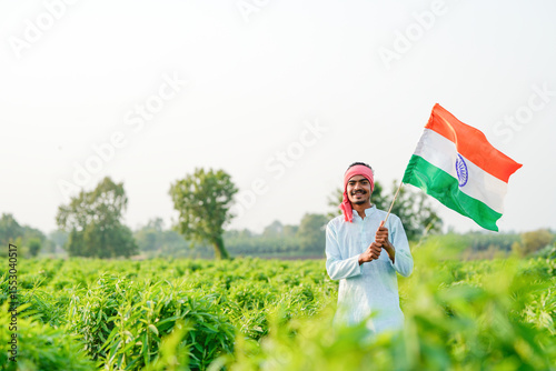 indian farmer waving national tricolor flag at agriculture field photo