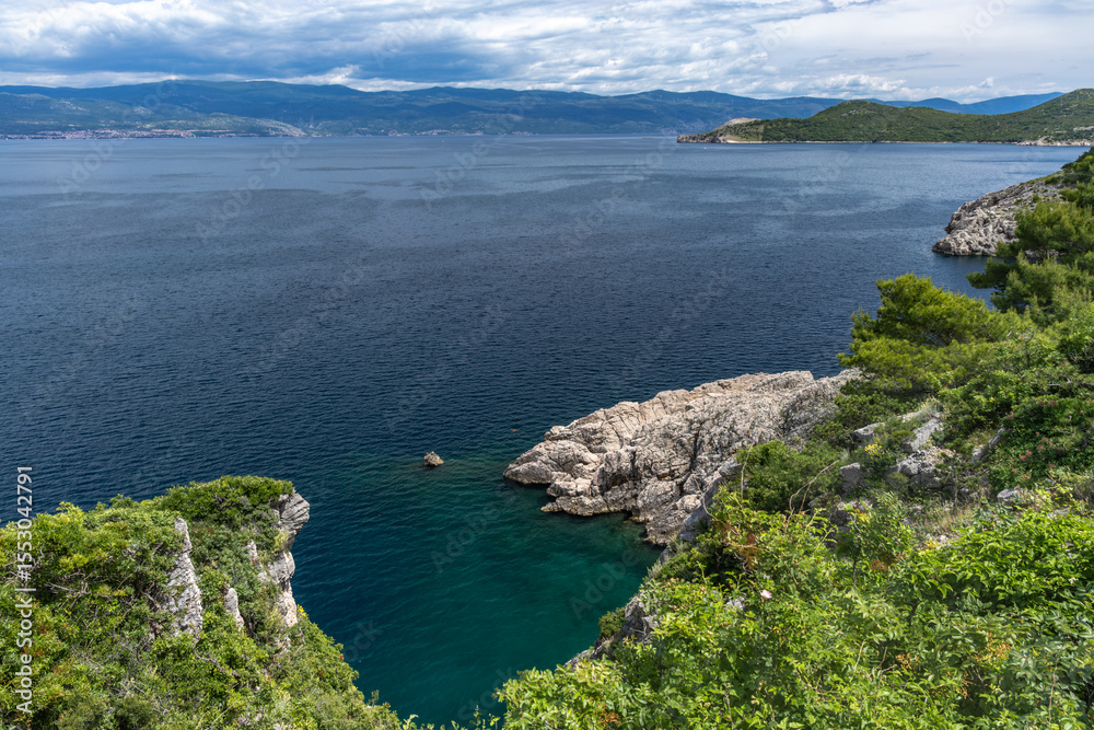 Fototapeta premium Pebbly Beach Kozica near the town of Vrbnik, azure water in the bay on the Adriatic Sea, a beach without people