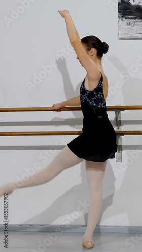 Dancer maintaining proper alignment during barre exercise, showcasing classical ballet technique and form.