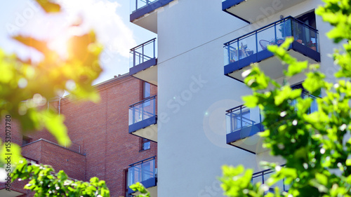 New modern block of flats in green area. complex. New modern block of flats in green area. European residential architecture harmonizing with nature. Eco-friendly living in city with greens.