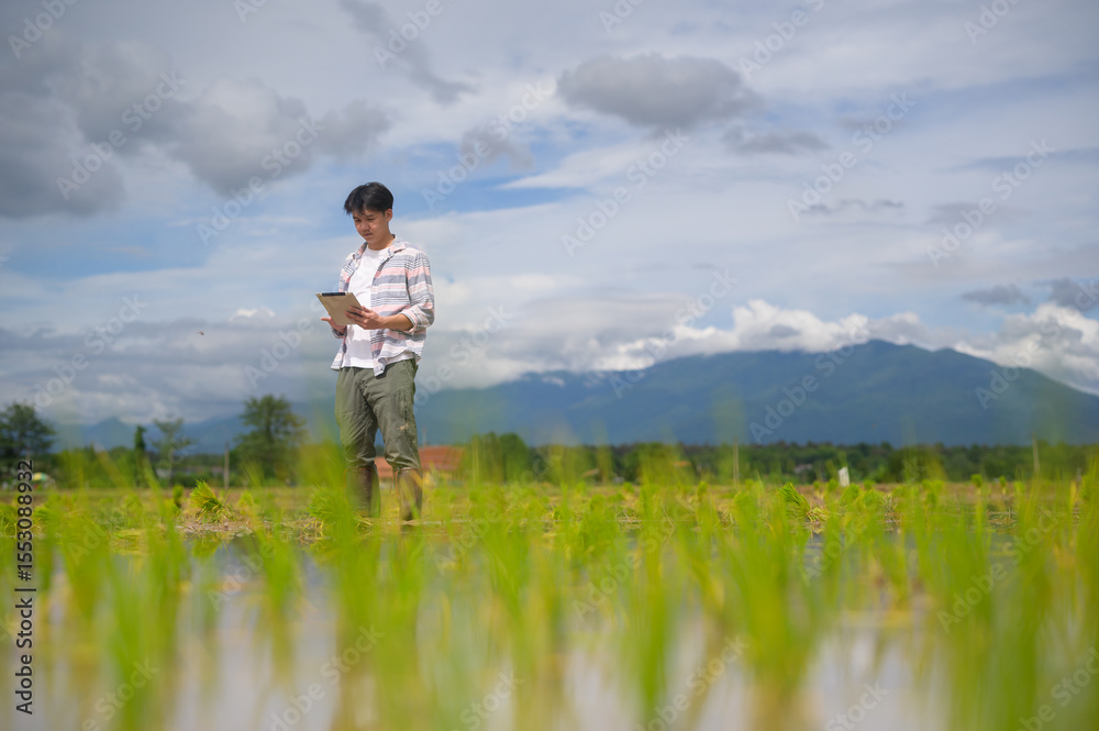 A man stands in a lush green field with a tablet, surrounded by nature and mountains under a partly cloudy sky. A man stands in a lush green field with a tablet, surrounded by nature and mountains under a partly cloudy sky.