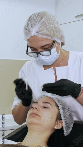 Beauty injection. anti-aging injections. botulinum therapy. Facial rejuvenation. Doctor wipes patient's forehead with antiseptic cotton pads, before beauty injections. Beauty concept.