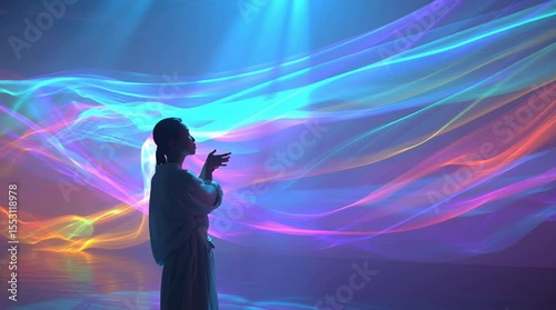 Woman interacts with colorful abstract light waves, creating a futuristic, ethereal scene.