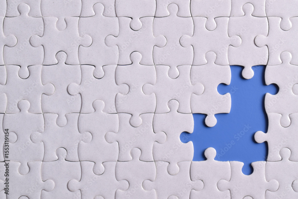 Fototapeta premium White puzzle with missing piece on blue background, closeup