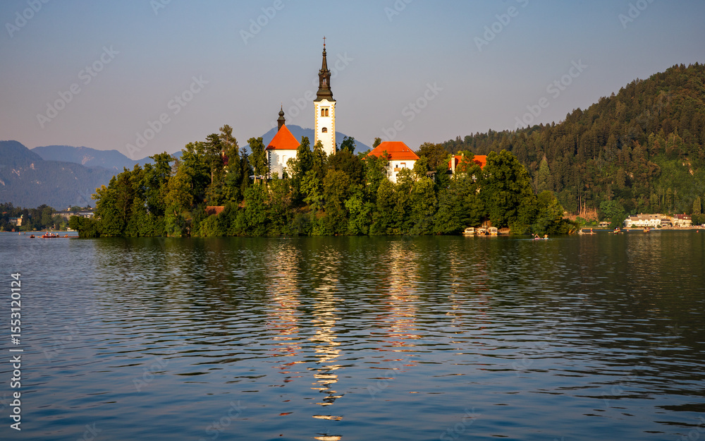 Obraz premium summer evening at Lake Bled - the island with the church are illuminated by the setting sun