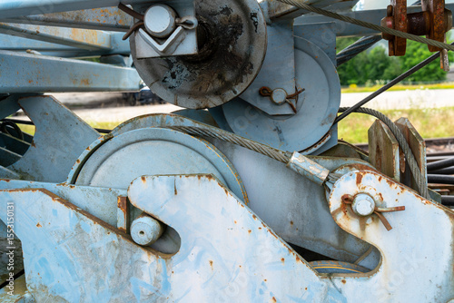 Closeup on older crane before erecting. Pulleys, steel cables and other parts can be seen here. Background.