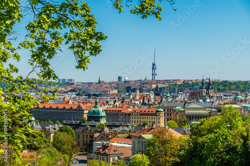 A tree framed view from the castle gardens towards central Prague in springtime