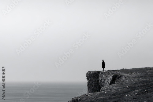 minimalist photograph of solitary figure standing on edge of coastal cliff in south africa at sunset