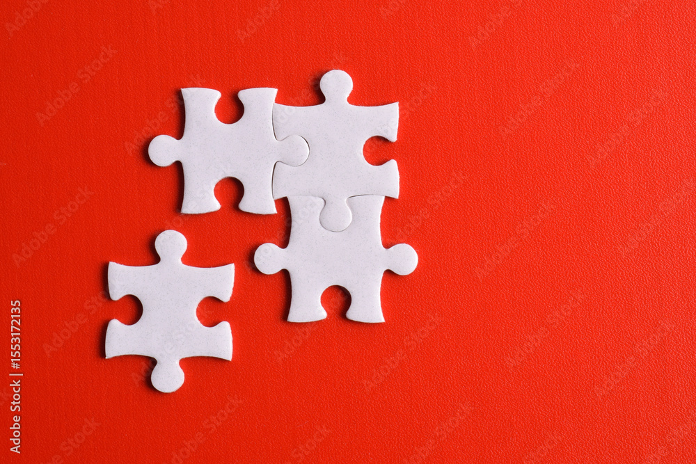 Obraz premium Four puzzle pieces on red background. The concept of finding the right solutions in teamwork.