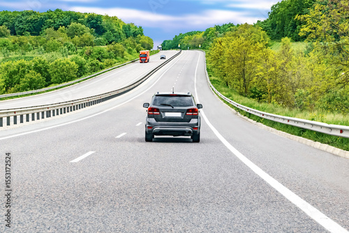 Highway mountain road goes up with cars automobiles.Scenic forest roadway nature landscape.European travel vacation route car concept