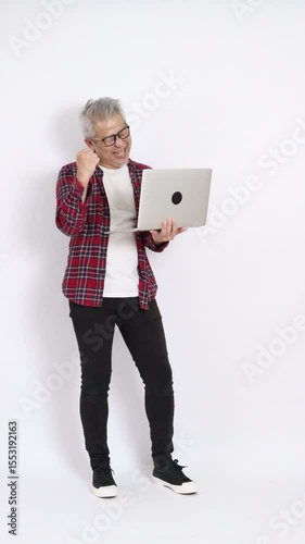 The elderly East Asian man wearing a red plaid shirt is standing against a white background.