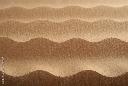 Close-up of layered corrugated cardboard showing undulating wavy texture and shadow patterns in warm brown tones