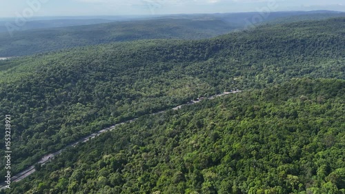 Drone footage of the Thailand forest. Aerial view of dense tropical rainforest with lush green trees under a blue sky. Natural forest landscape in Southeast Asia
