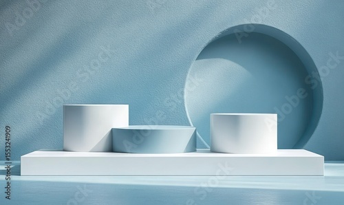 Minimalist light blue scene with three white cylindrical and rectangular platforms and a round recessed wall feature casting soft shadows