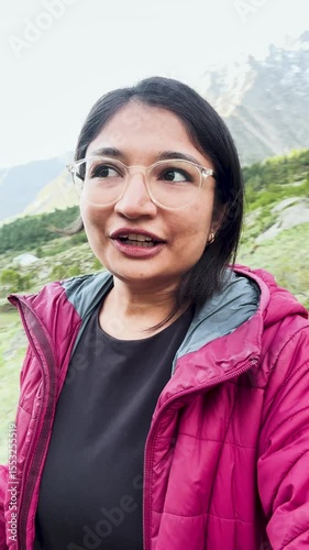 4k vertical selfie video of Indian young woman vlogging during trekking in mountains at Miyar Valley, Himachal Pradesh, India. Happy tourist hiking, sharing experience on social media. Travel blogger