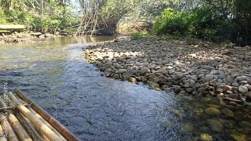 traveling sailing bamboo raft on river in tropical forest jungle